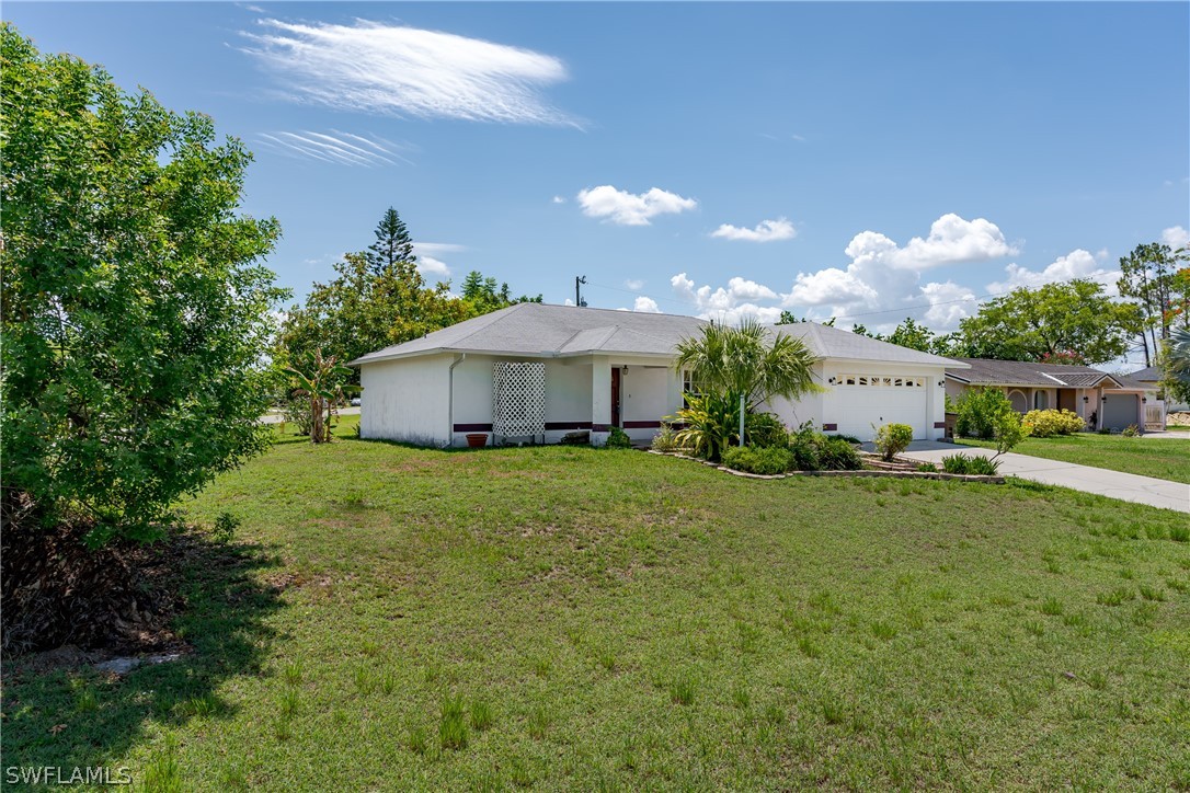 234 Connecticut Road Lehigh Acres, FL 33936 - Photo 3 of 19 a front view of a house with garden