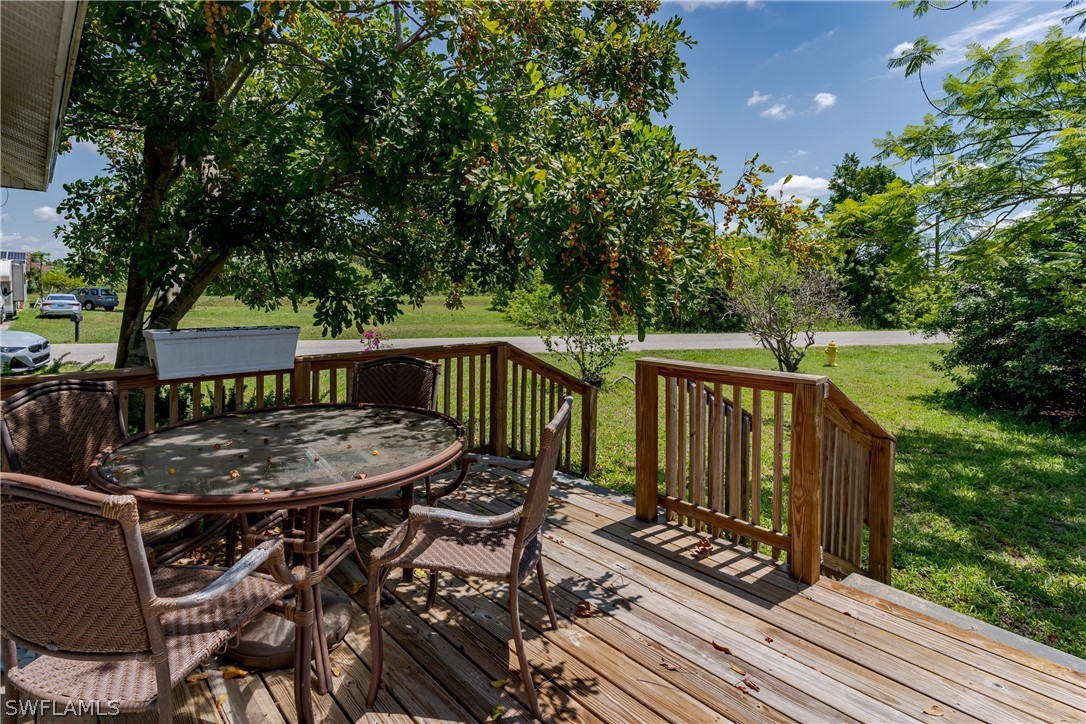 234 Connecticut Road Lehigh Acres, FL 33936 - Photo 4 of 19 a view of a roof deck with table and chairs a barbeque with wooden floor and fence