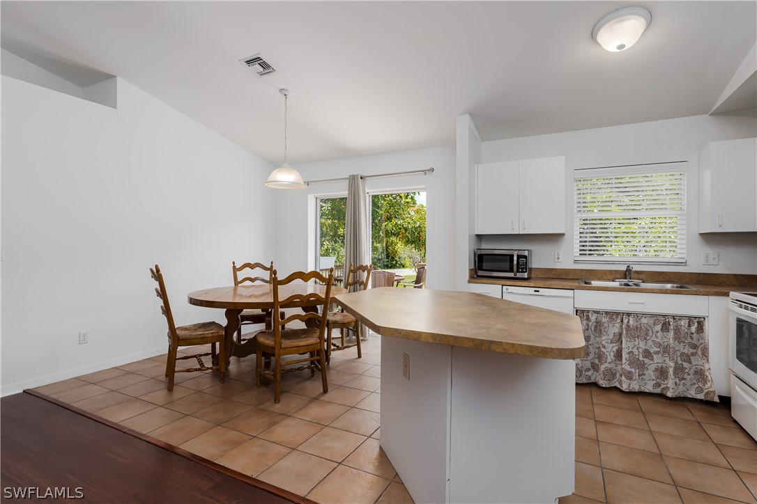234 Connecticut Road Lehigh Acres, FL 33936 - Photo 8 of 19 a dining hall with stainless steel appliances granite countertop a stove a sink a dining table and chairs