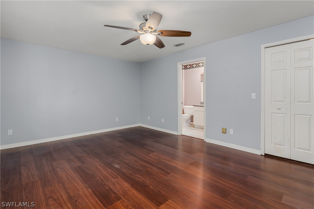 234 Connecticut Road Lehigh Acres, FL 33936 - Photo 9 of 19 a view of an empty room with wooden floor and a ceiling fan