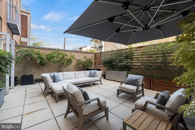 a view of a patio with couches under an umbrella