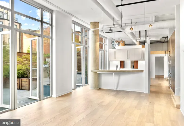 a view of a large kitchen with stainless steel appliances kitchen island granite countertop a refrigerator and a sink