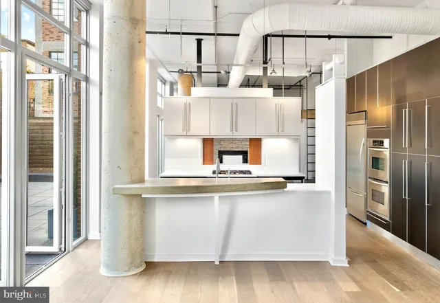 a kitchen with kitchen island a counter top space and stainless steel appliances