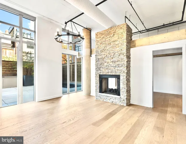 a view of an empty room with a fireplace and a window