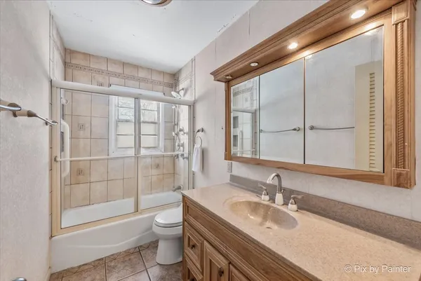 a bathroom with a granite countertop sink toilet a mirror and shower