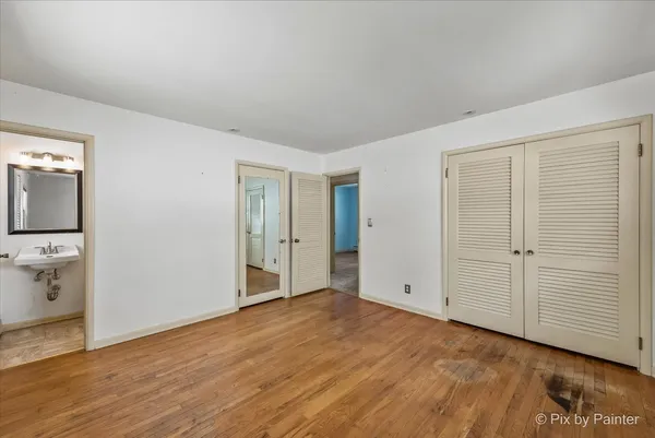 an empty room with wooden floor and mirror