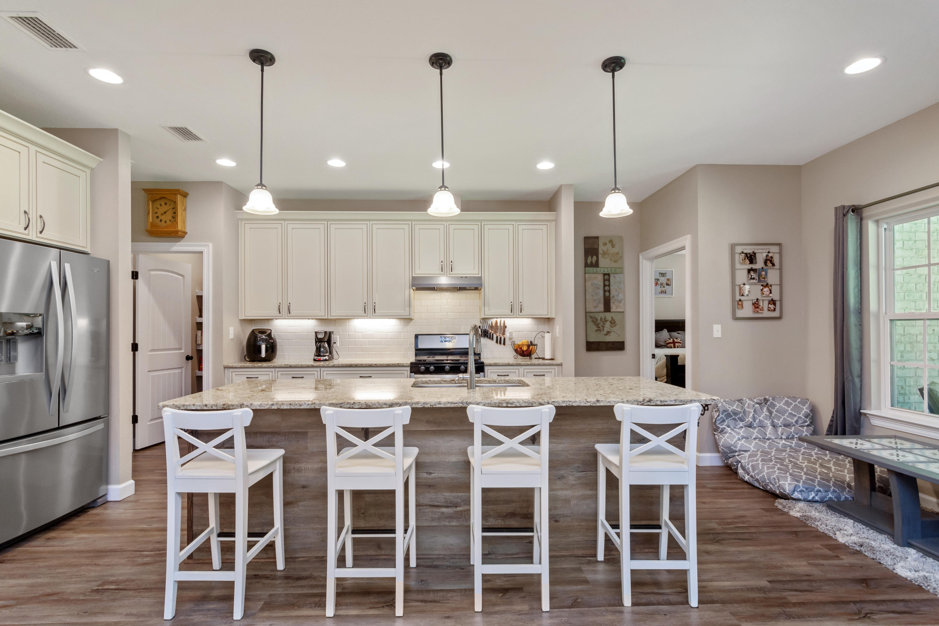 6076 Carina Road Crestview, FL 32539 - Photo 14 of 38 a dining room with stainless steel appliances kitchen island granite countertop a table chairs and a kitchen view