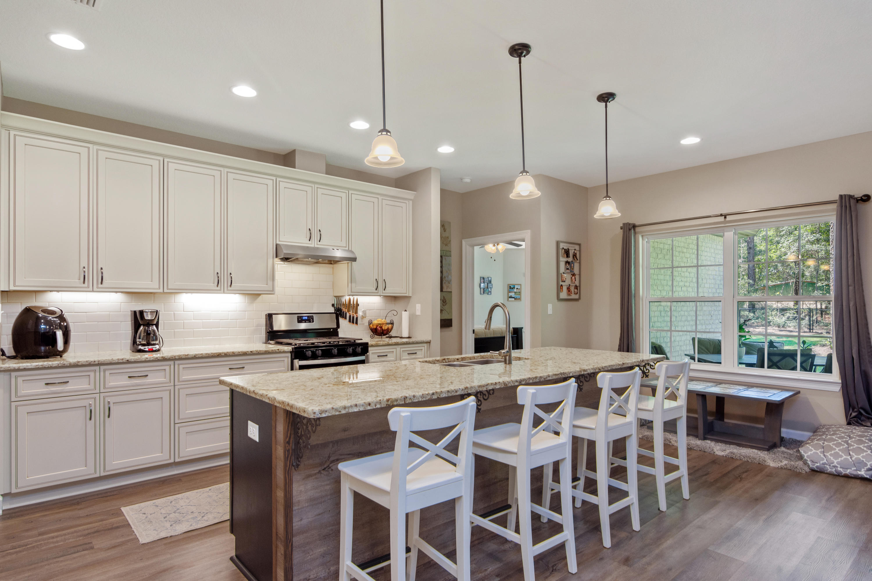6076 Carina Road Crestview, FL 32539 - Photo 17 of 38 a kitchen with stainless steel appliances granite countertop a stove a sink a kitchen island with a dining table and chairs