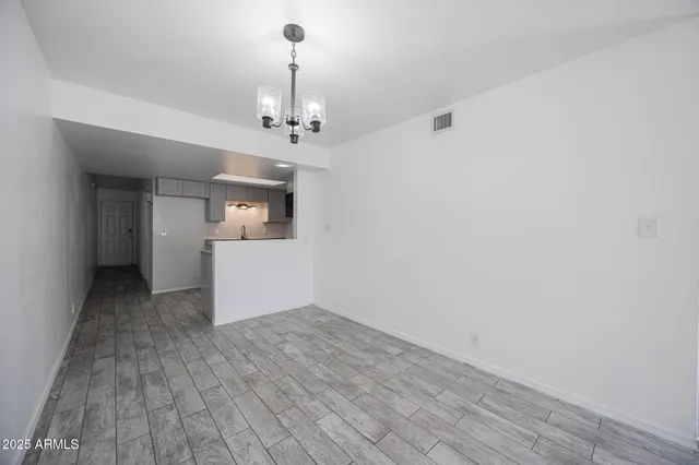 a view of a big room with wooden floor and windows