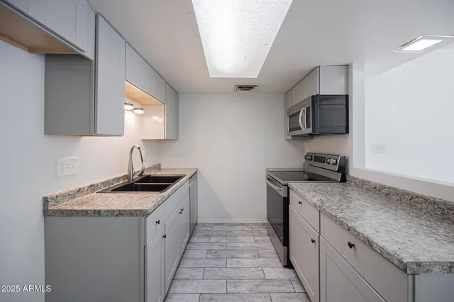 a kitchen with granite countertop a sink and a stove