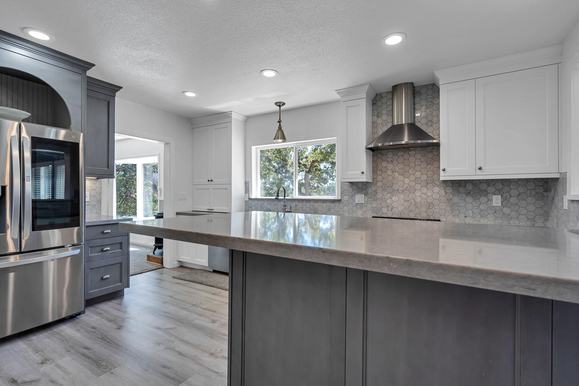 24898 Long Street Fall River Mills, CA 96028 - Photo 11 of 50 a large kitchen with stainless steel appliances a large counter top a stove a sink a refrigerator and a window