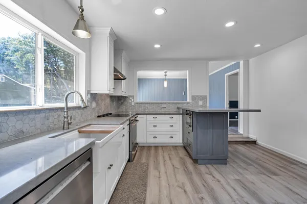 a kitchen with a sink stove and cabinets