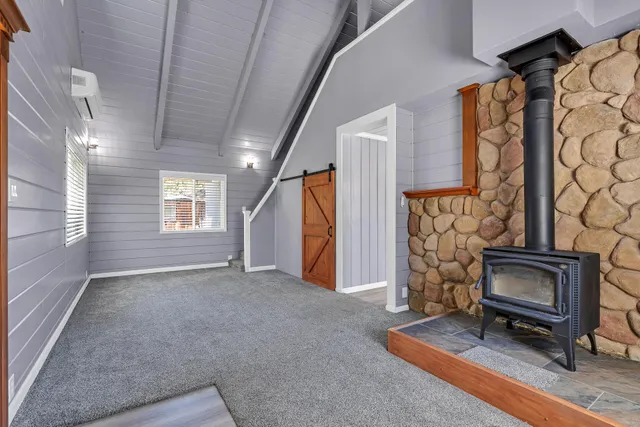 a view of an empty room with a fireplace and a window
