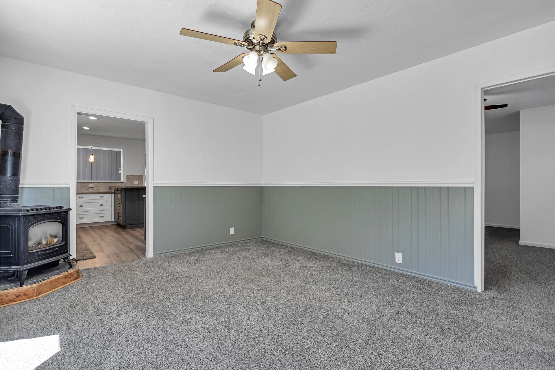 24898 Long Street Fall River Mills, CA 96028 - Photo 28 of 50 an empty room with a fireplace and a chandelier fan