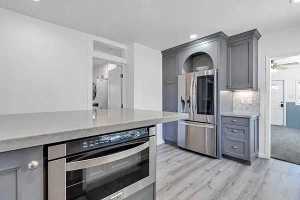 a view of a kitchen counter space with stainless steel appliances wooden floor and cabinets