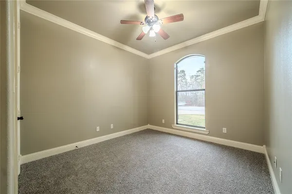 an empty room with windows and ceiling fan