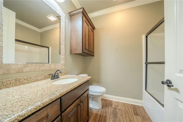 a bathroom with a granite countertop sink toilet and shower