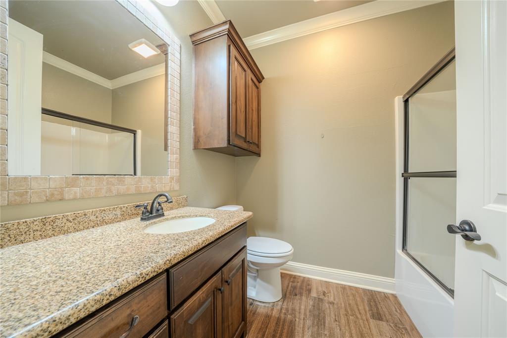 2114 West Hawkins Parkway Longview, TX 75605 - Photo 16 of 27 a bathroom with a granite countertop sink toilet and shower