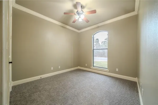 an empty room with a window and a ceiling fan