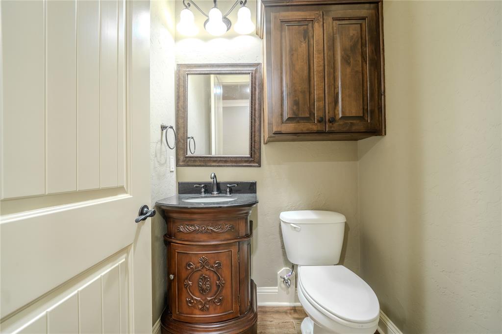 2114 West Hawkins Parkway Longview, TX 75605 - Photo 19 of 27 a bathroom with a toilet a sink and mirror