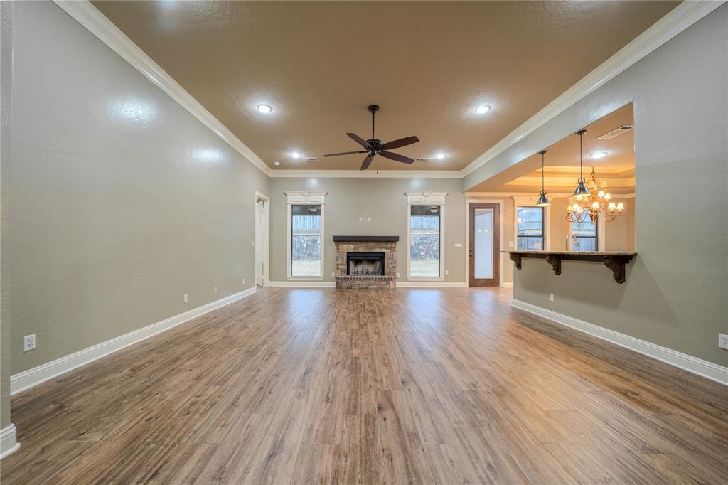 2114 West Hawkins Parkway Longview, TX 75605 - Photo 4 of 27 an empty room with wooden floor fireplace and windows