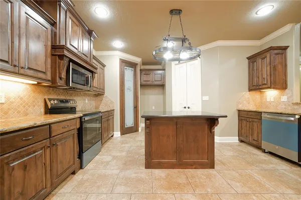 a large kitchen with stainless steel appliances granite countertop a stove and a sink