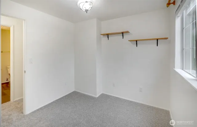 an empty room with a window and a fan