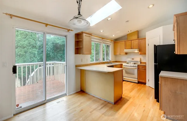 a kitchen with a counter top space a sink appliances and cabinets