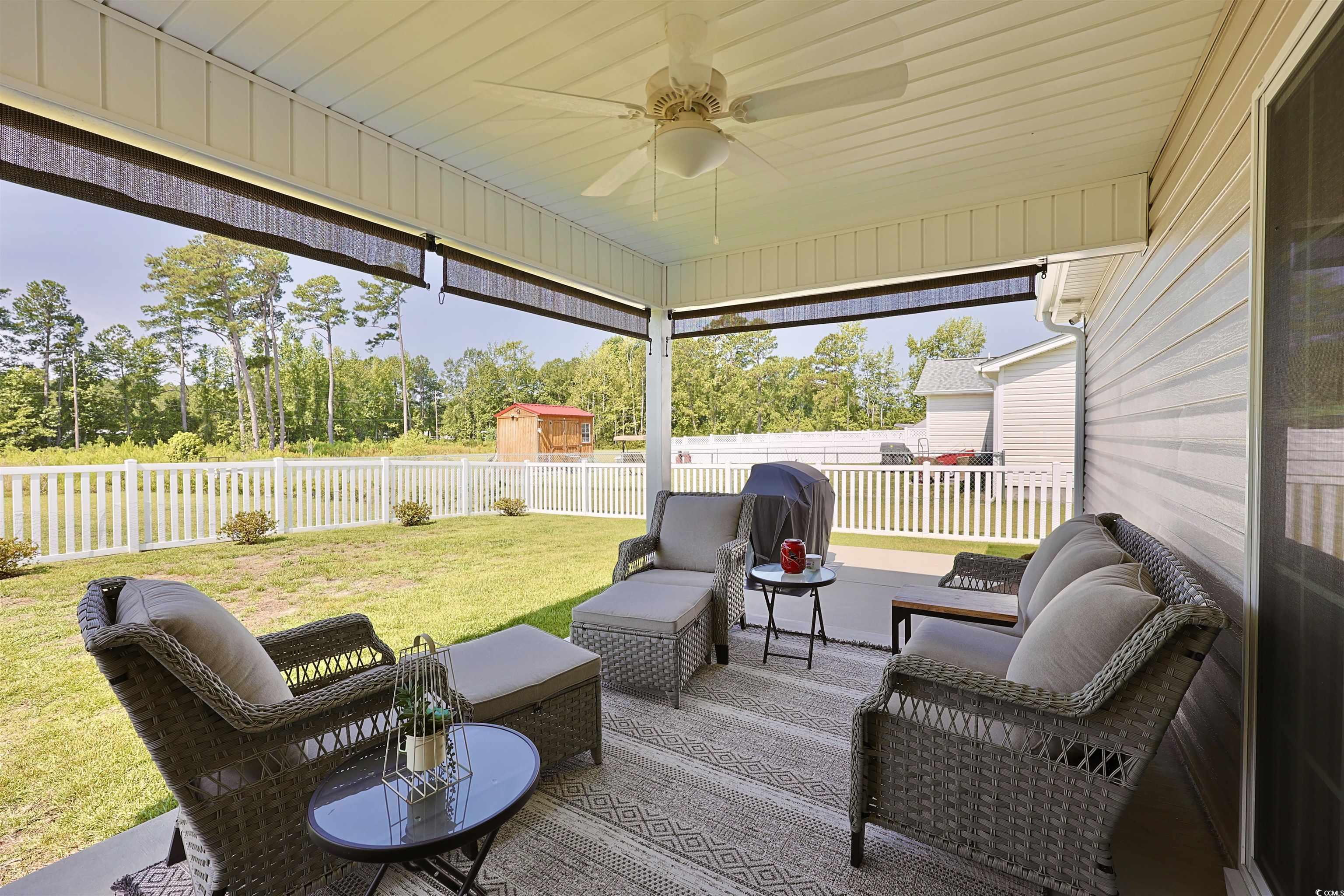 3604 Church Street Loris, SC 29569 - Photo 24 of 34 Wooden terrace with ceiling fan, a fenced backyard, and an outdoor hangout area