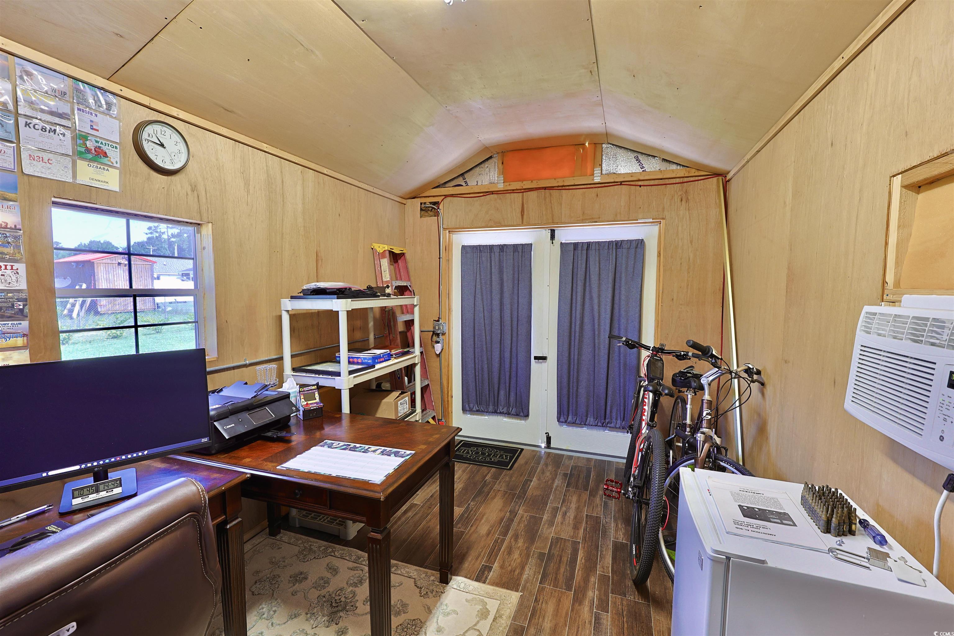 3604 Church Street Loris, SC 29569 - Photo 32 of 34 Home office with lofted ceiling, wood finished floors, wooden walls, and a wall mounted AC