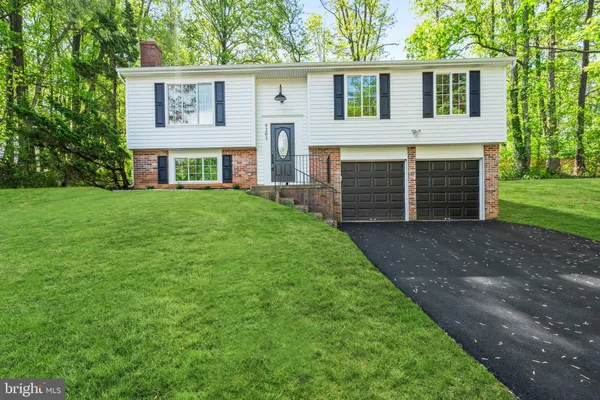 a front view of a house with a garden and yard