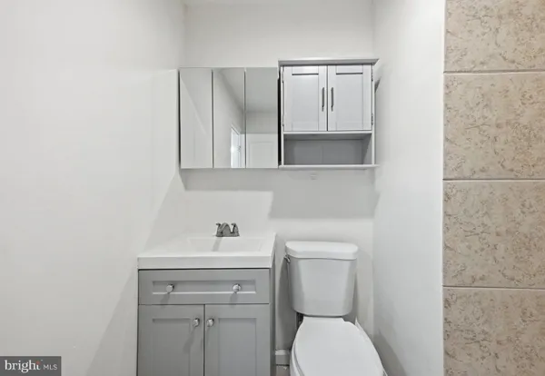 a bathroom with a toilet a sink a vanity and mirror