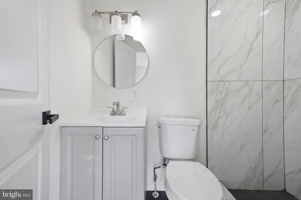 a bathroom with a toilet a sink a vanity and mirror