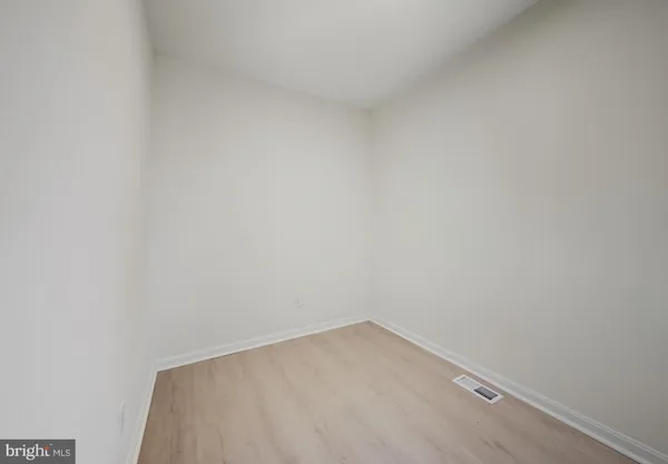 a view of an empty room with closet and a window
