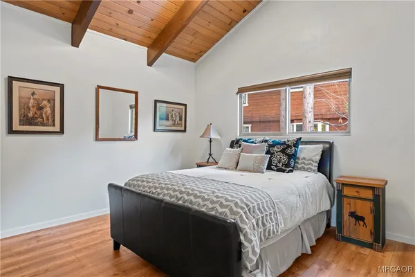 a view of a wooden house with a bench and trees