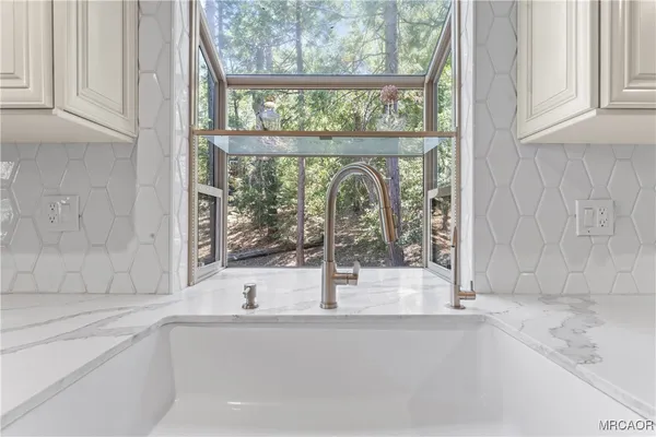 a patio with table and chairs and potted plants
