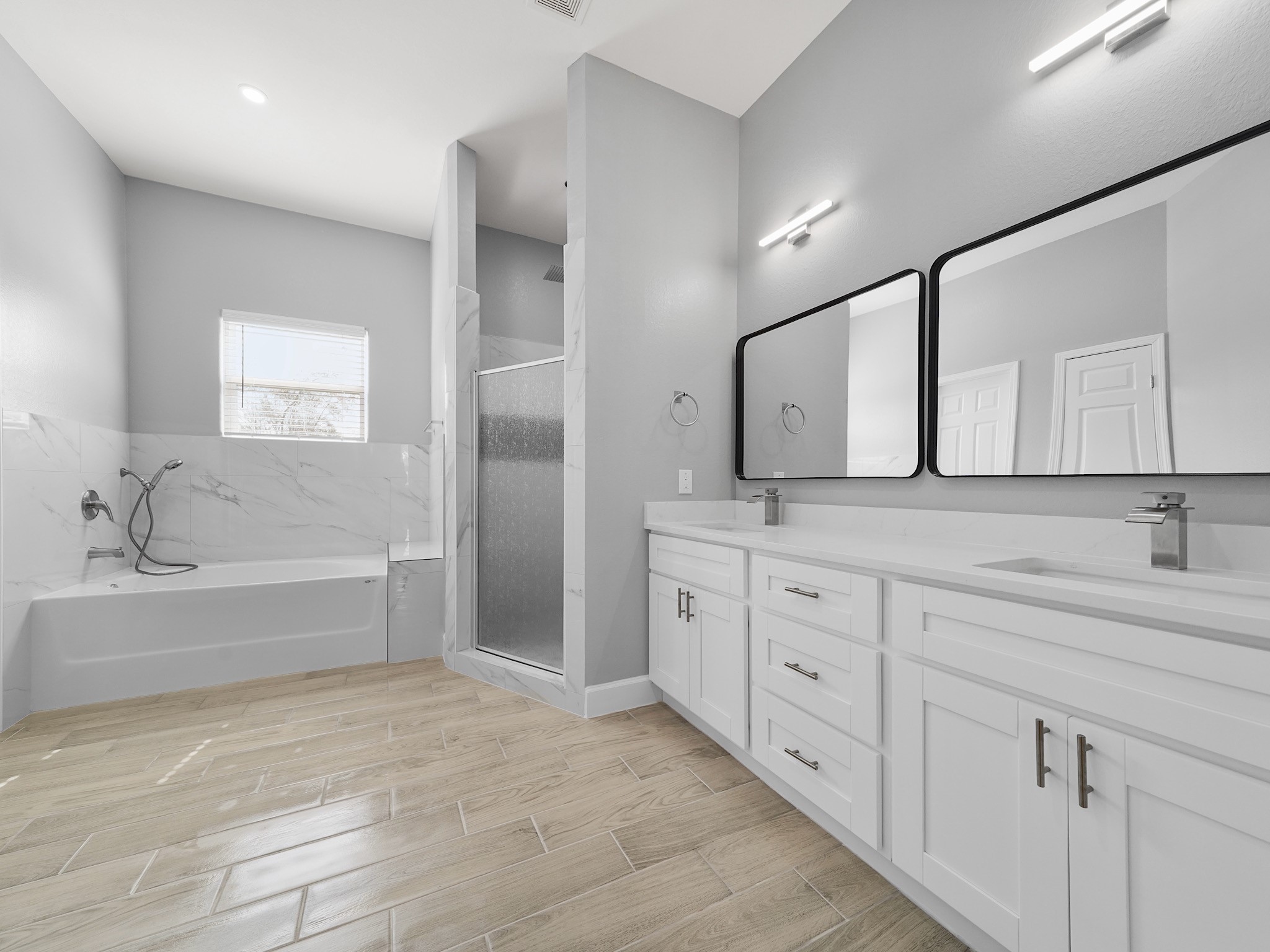 2448 Areba Street Houston, TX 77091 - Photo 11 of 19 Unwind in the luxurious primary bath featuring dual sinks, a soaking tub, and a separate shower for a spa-like experience at home.