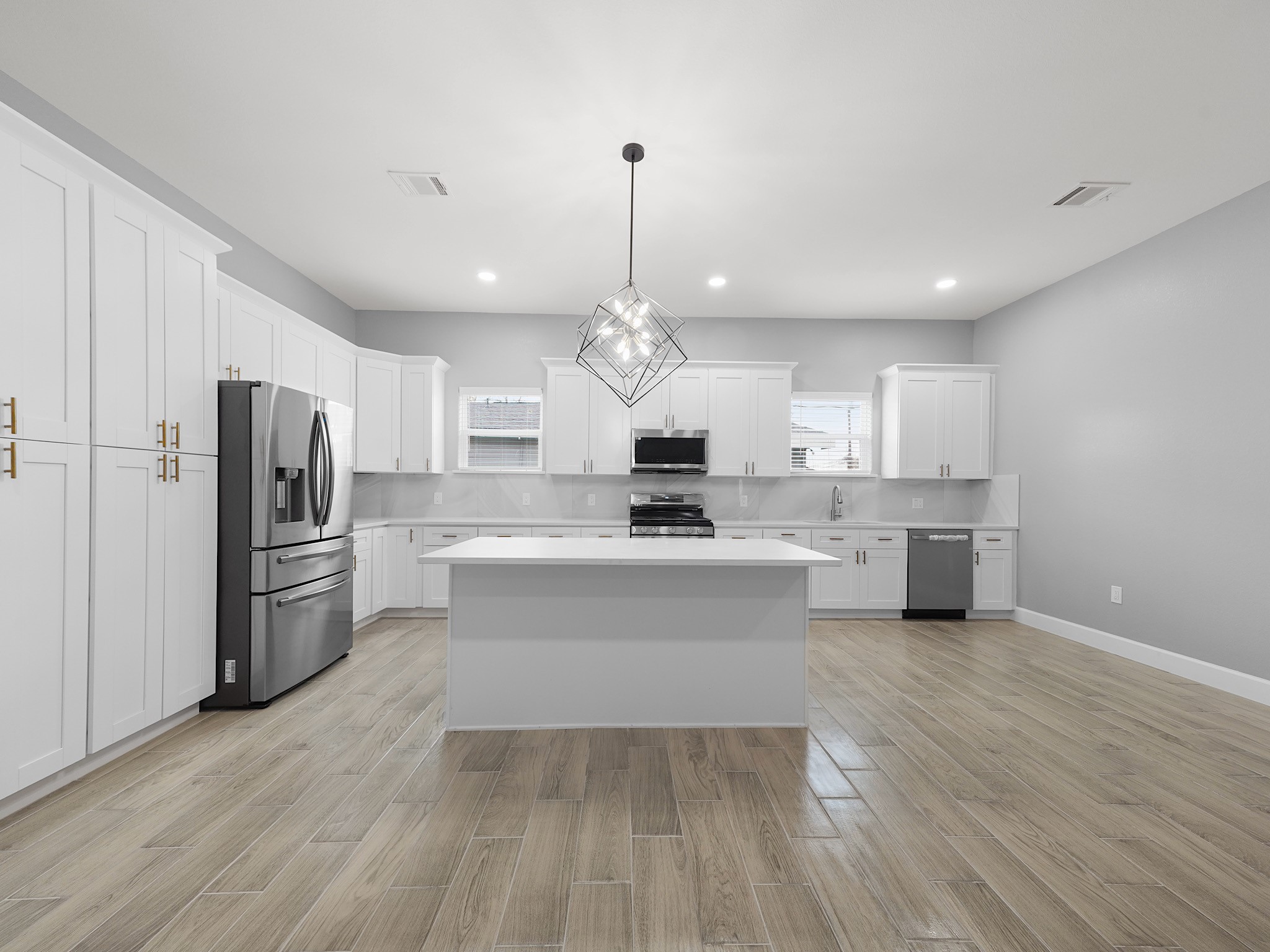 2448 Areba Street Houston, TX 77091 - Photo 6 of 19 This modern kitchen features quartz countertops, stainless steel appliances, gas cooking, and a large island perfect for meal prep or casual dining.