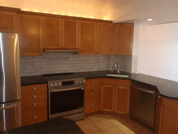 a kitchen with stainless steel appliances granite countertop a refrigerator and a sink