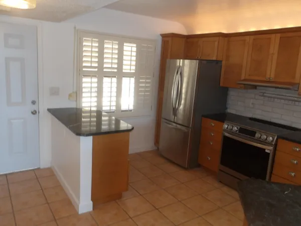 a kitchen with granite countertop a refrigerator and a stove