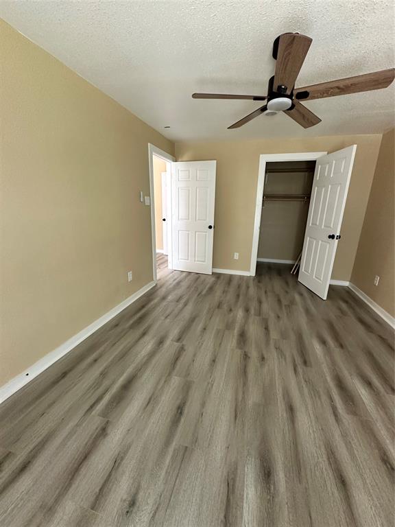 4101 North 19th Street Waco, TX 76708 - Photo 5 of 8 Unfurnished bedroom with a closet, wood-style floors, a textured ceiling, and ceiling fan