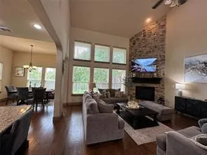 a living room with furniture a fireplace and a floor to ceiling window