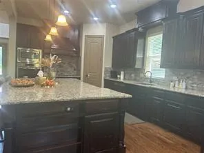 a bathroom with a granite countertop sink a large mirror and a shower
