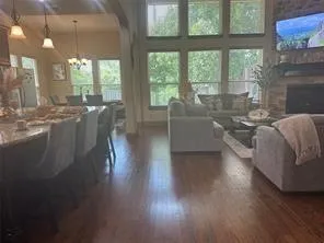 a living room with furniture a large window and wooden floor
