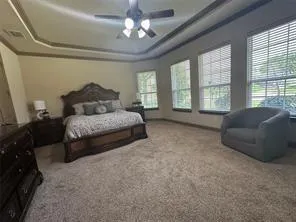 a spacious bedroom with a bed couch and a large window