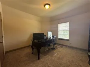 a view of a workspace with furniture and a window