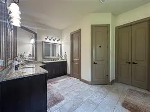 a bathroom with a granite countertop sink a mirror and a shower