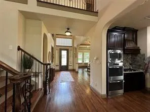 a view of a hallway with wooden floor and staircase