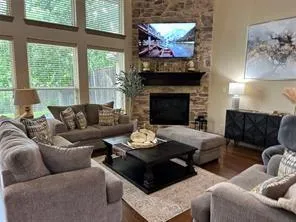 a living room with furniture a flat screen tv and a fireplace