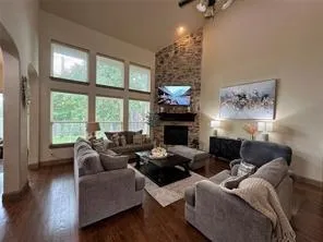 a living room with furniture a large window and a fireplace